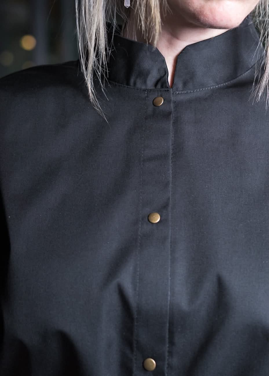 Detail of a chef shirt placket with brass snaps